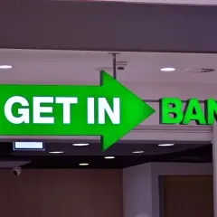 Zielony neon z napisem "GET IN BANK" i strzałką.